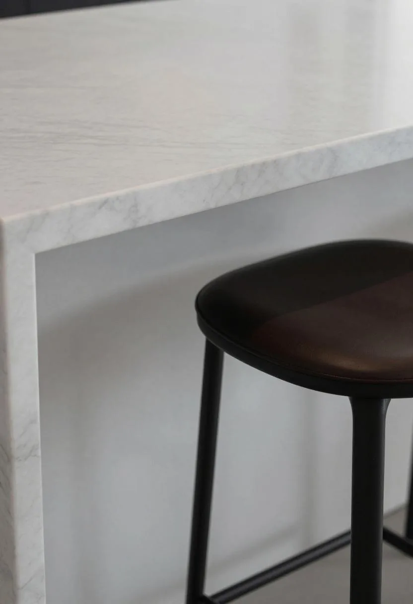 Modern marble waterfall island edge with dark leather and metal stool